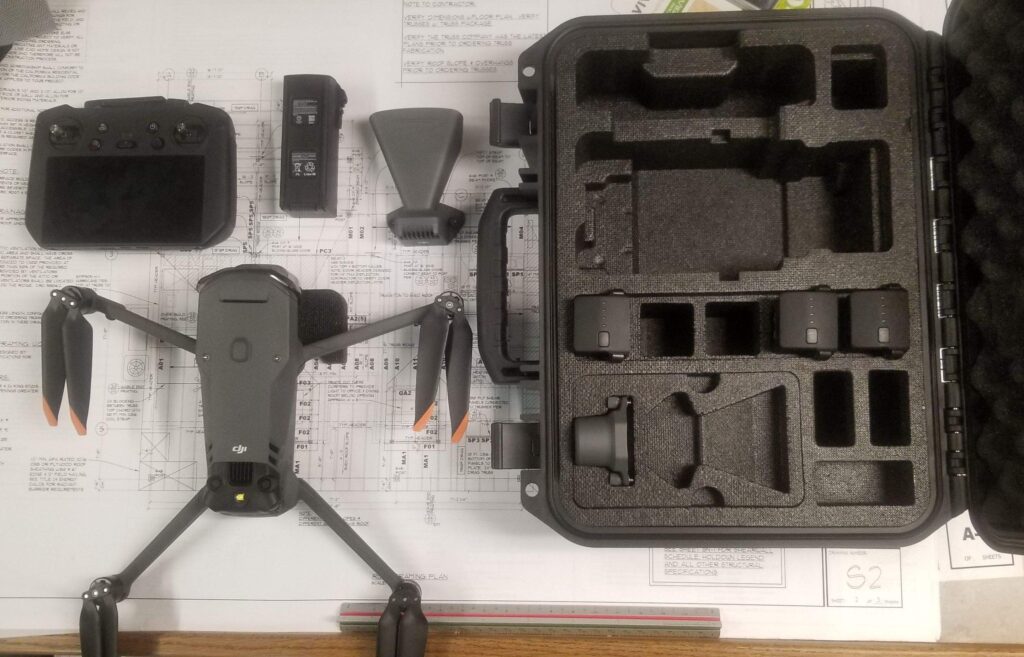 Latest drone technology used by Richard Hockett Roofing, displayed atop architectural plans, showcasing our commitment to innovative roofing solutions.