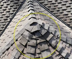 damaged and lifted asphalt shingles on roof showing a common cause of roof leaks in california